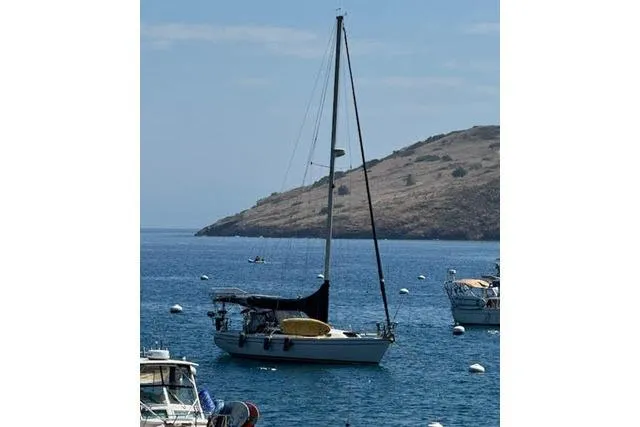 Slide: The Image of Catalina 34 Mk II sailboat from 2000 anchored in a scenic bay with hills. - 46