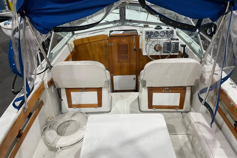 Slide: The Image of 1989 Limestone 24 boat interior with steering wheel, wooden accents, and blue canopy. - 15