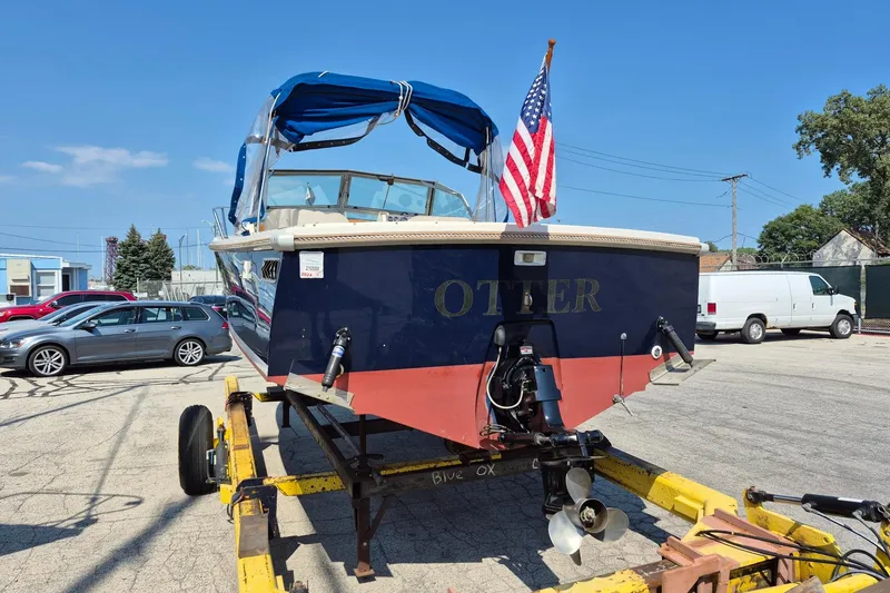Slide: The Image of 1989 Limestone 24 boat on trailer with American flag, parked in lot. - 4