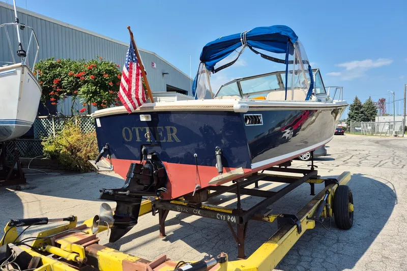Slide: The Image of 1989 Limestone 24 boat with American flag, docked on trailer, sunny day. - 7