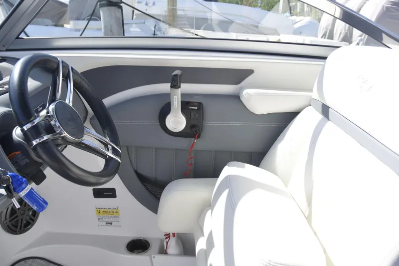 Slide: The Image of Interior of a 2020 Cobalt 23SC boat, featuring steering wheel and throttle controls. - 10