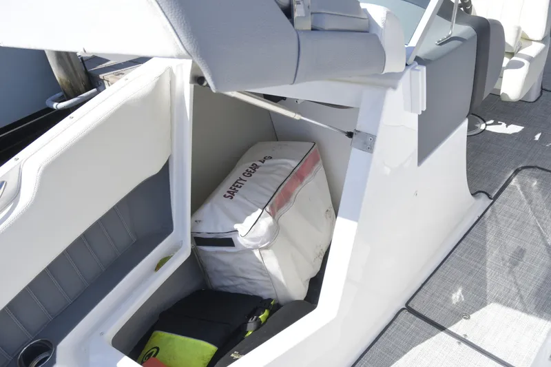 Slide: The Image of 2020 Cobalt 23SC boat storage compartment with safety gear and life jackets. - 12