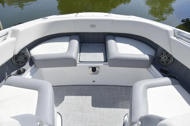 Slide: The Image of 2020 Cobalt 23SC boat interior with gray and white seating, cup holders, and speakers. - 16
