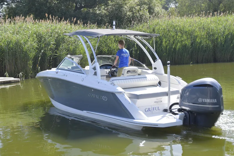 Slide: The Image of 2020 Cobalt 23SC boat with Yamaha engine cruising on a calm waterway. - 3