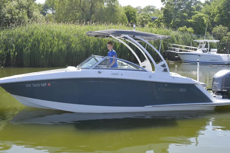 Slide: The Image of 2020 Cobalt 23SC boat on calm water with lush greenery background. - 4