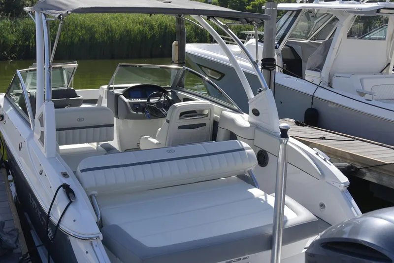 Slide: The Image of 2020 Cobalt 23SC boat with sleek interior, docked beside other vessels. - 8