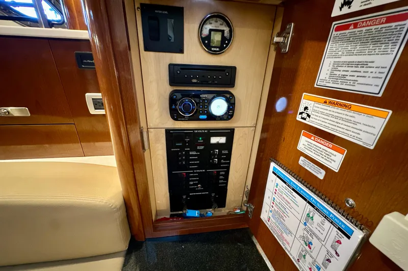 Slide: The Image of Control panel inside 2012 Sea Ray 330 Sundancer boat, featuring gauges and warning labels. - 14