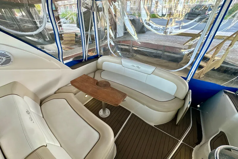 Slide: The Image of 2012 Sea Ray 330 Sundancer interior with cushioned seating and wooden table. - 4