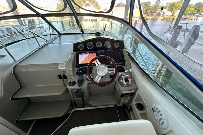 Slide: The Image of 2012 Sea Ray 330 Sundancer helm with navigation system and wooden steering wheel. - 5