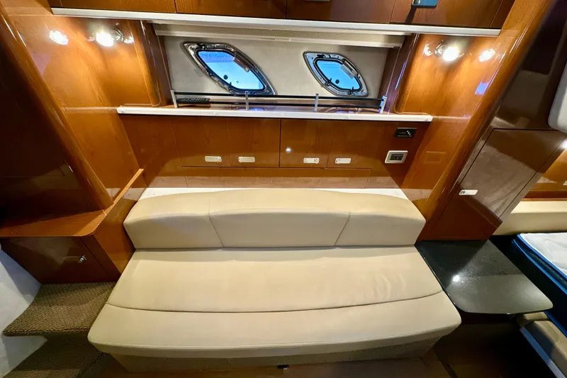 Slide: The Image of Interior of 2012 Sea Ray 330 Sundancer with beige seating and wooden cabinetry. - 8