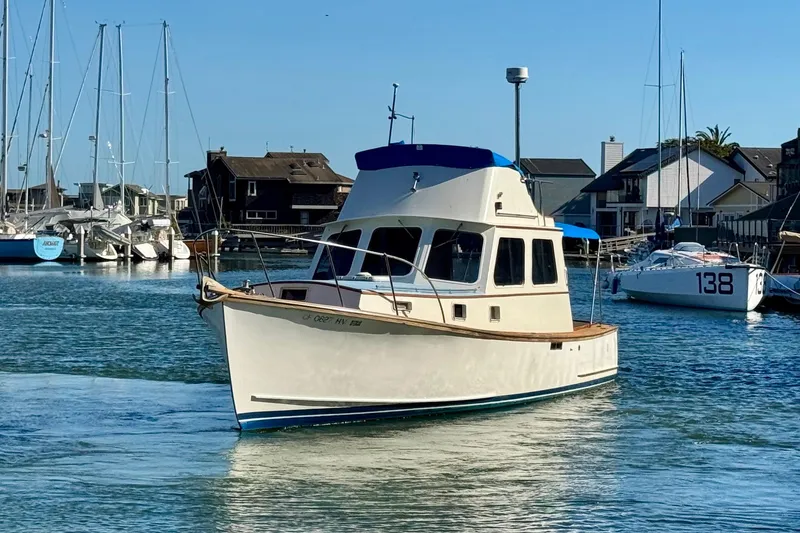 The Image of 1982 Jarvis Newman Flybridge Cruiser sailing near a scenic coastline. - 0