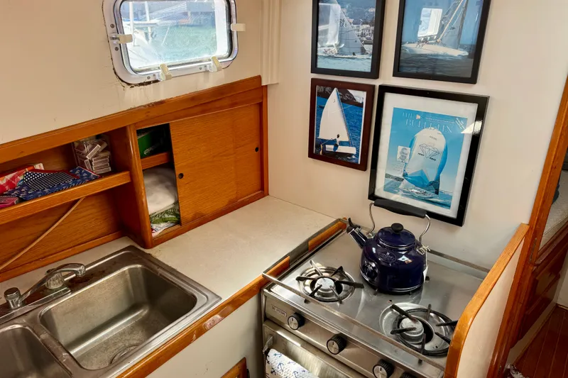 Slide: The Image of 1982 Jarvis Newman Flybridge Cruiser kitchen with wood cabinets, stove, and sink. - 13