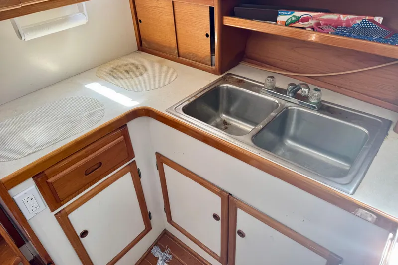 Slide: The Image of 1982 Jarvis Newman Flybridge Cruiser kitchen with stove, sink, and sailing-themed wall art. - 14