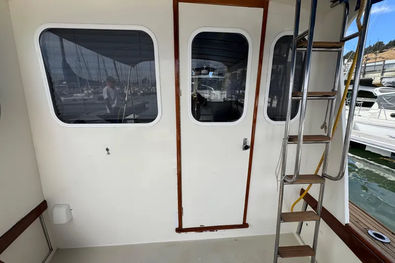 Slide: The Image of 1982 Jarvis Newman Flybridge Cruiser with open refrigerator drawer, showcasing interior storage. - 19