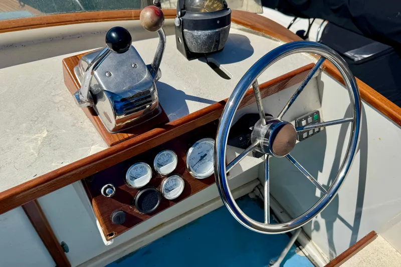 Slide: The Image of 1982 Jarvis Newman Flybridge Cruiser helm with steering wheel and control panel. - 34