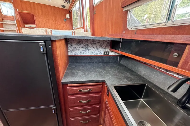Slide: The Image of 1981 Tollycraft 43 Motor Yacht kitchen with black countertop and stainless steel sink. - 18