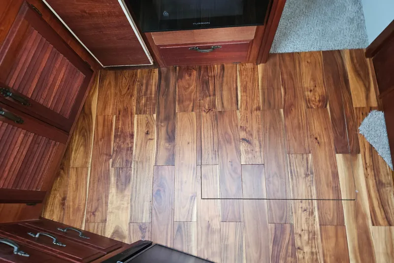 Slide: The Image of Wooden flooring inside a 1981 Tollycraft 43 Motor Yacht, featuring rich grain patterns. - 21