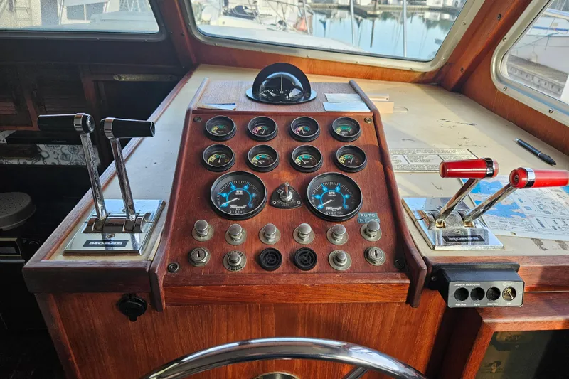 Slide: The Image of 1981 Tollycraft 43 Motor Yacht helm with gauges and controls, docked at marina. - 22