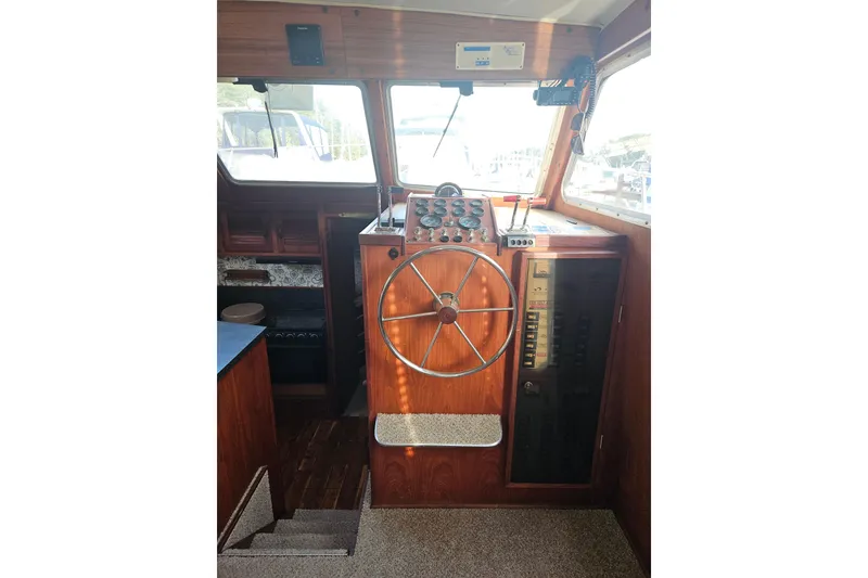 Slide: The Image of 1981 Tollycraft 43 Motor Yacht helm with wooden steering wheel and control panel. - 23