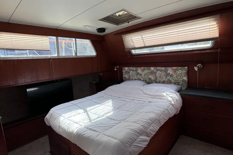 Slide: The Image of 1981 Tollycraft 43 Motor Yacht bedroom with floral headboard and natural light. - 29