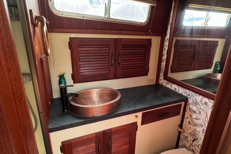 Slide: The Image of 1981 Tollycraft 43 Motor Yacht bathroom with copper sink and wooden cabinets. - 32