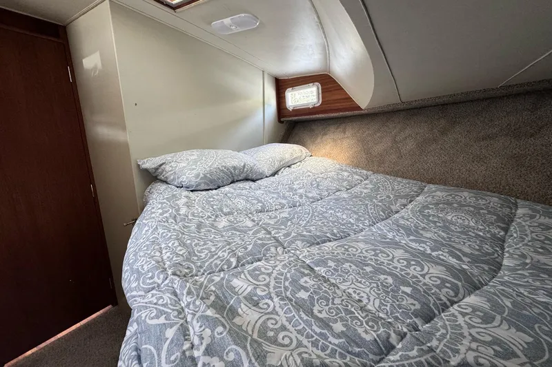 Slide: The Image of Cozy bedroom in 1981 Tollycraft 43 Motor Yacht with patterned bedding and small window. - 37