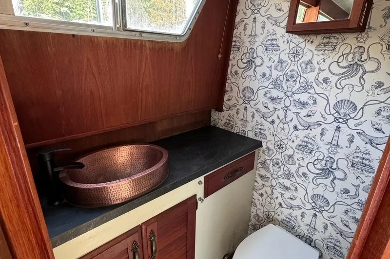 Slide: The Image of 1981 Tollycraft 43 Motor Yacht bathroom with nautical wallpaper and copper sink. - 40