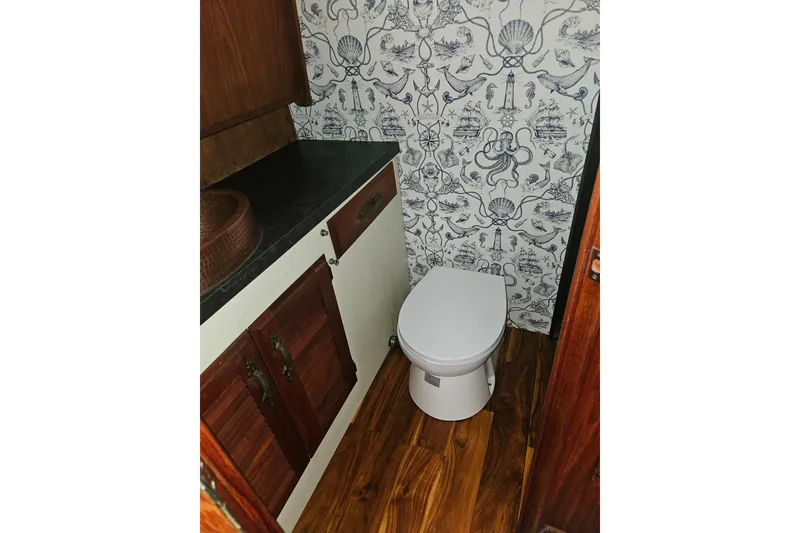 Slide: The Image of 1981 Tollycraft 43 Motor Yacht bathroom with nautical wallpaper and wooden cabinetry. - 41