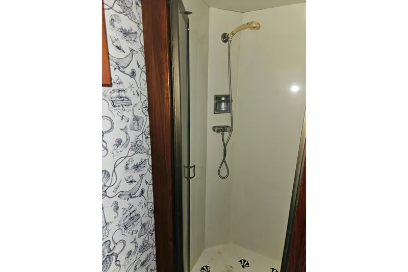 Slide: The Image of Shower area in 1981 Tollycraft 43 Motor Yacht with nautical-themed wallpaper. - 42