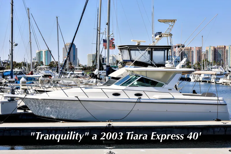 The Image of 2003 Tiara 4000 EXPRESS yacht "Tranquility" docked in marina with cityscape background. - 0