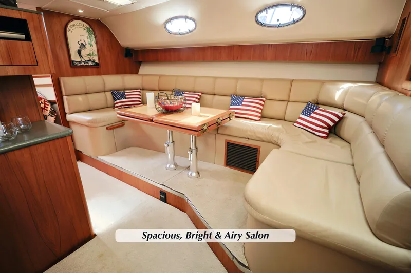 Slide: The Image of Luxurious 2003 Tiara 4000 EXPRESS yacht salon with plush seating and American flag pillows. - 18