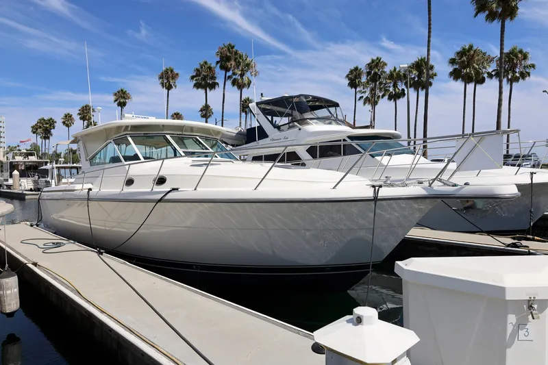 Slide: The Image of 2003 Tiara 4000 EXPRESS yacht docked at marina with palm trees in background. - 2