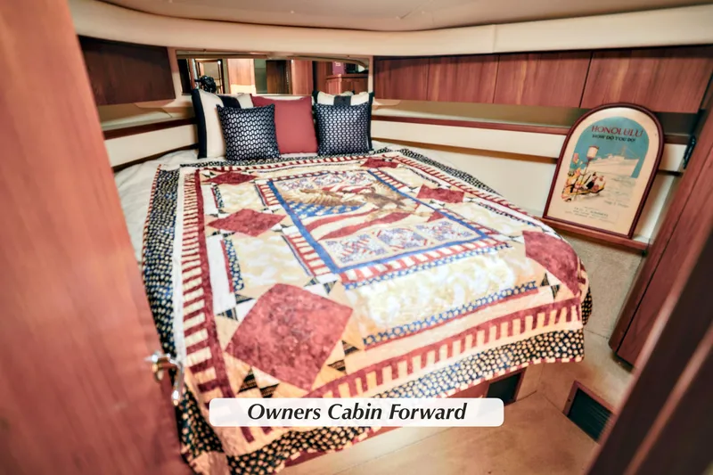 Slide: The Image of Owner's cabin in 2003 Tiara Yachts 4000 Express, featuring a colorful quilt and cozy decor. - 25