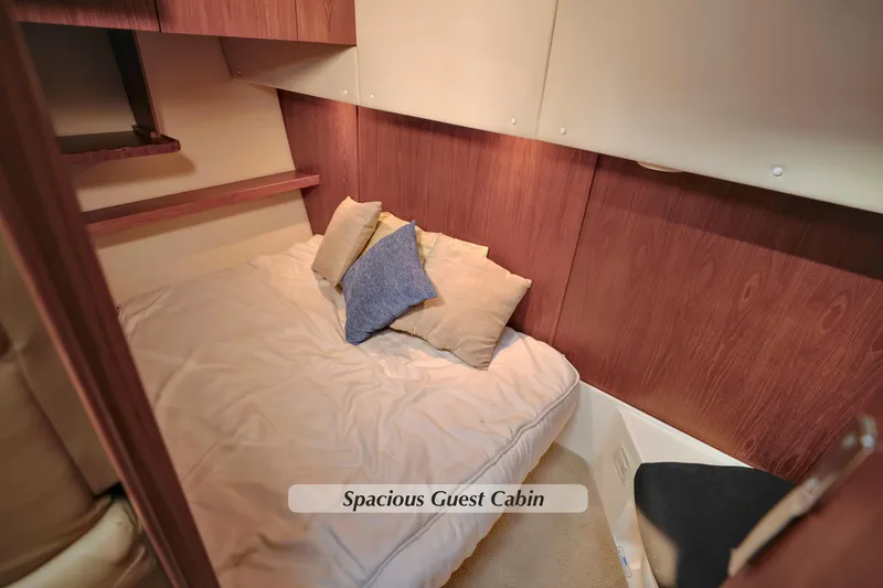Slide: The Image of Spacious guest cabin in 2003 Tiara Yachts 4000 Express, featuring cozy bedding and wood paneling. - 27