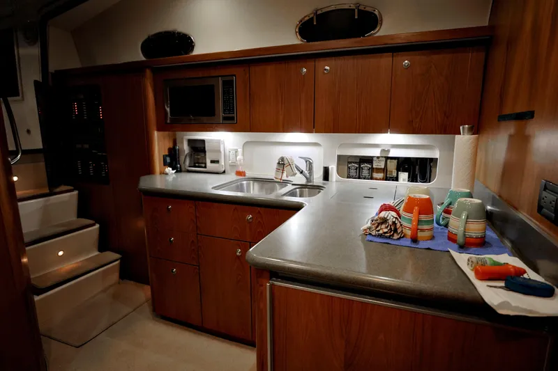 Slide: The Image of 2003 Tiara Yachts 4000 Express kitchen with wooden cabinets, sink, and microwave. - 31