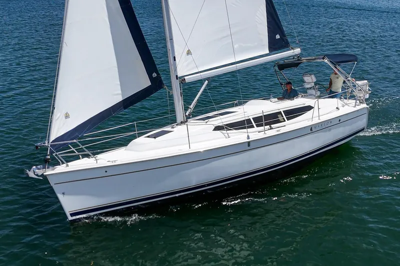 The Image of 2015 Hunter 33 sailboat cruising on open water with full sails. - 0