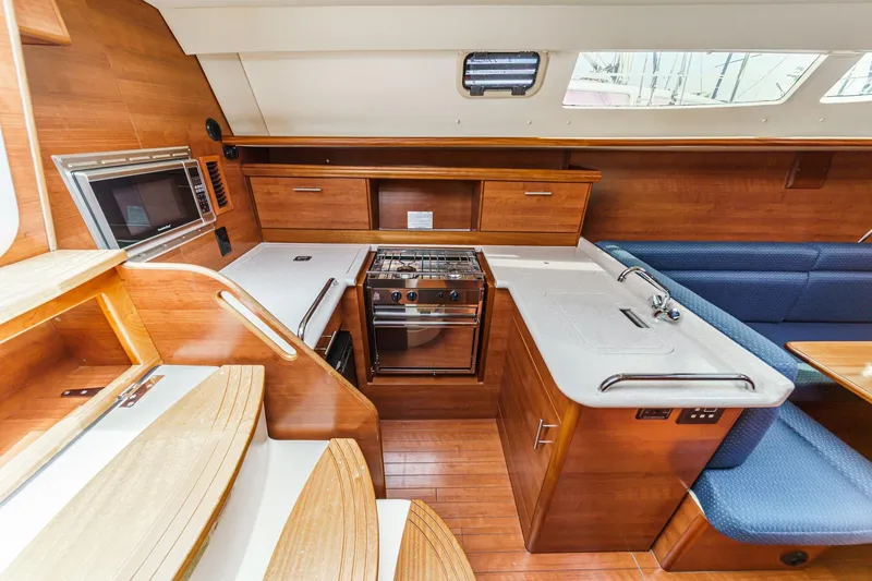 Slide: The Image of Interior of 2015 Hunter 33 sailboat featuring modern kitchen and seating area. - 9