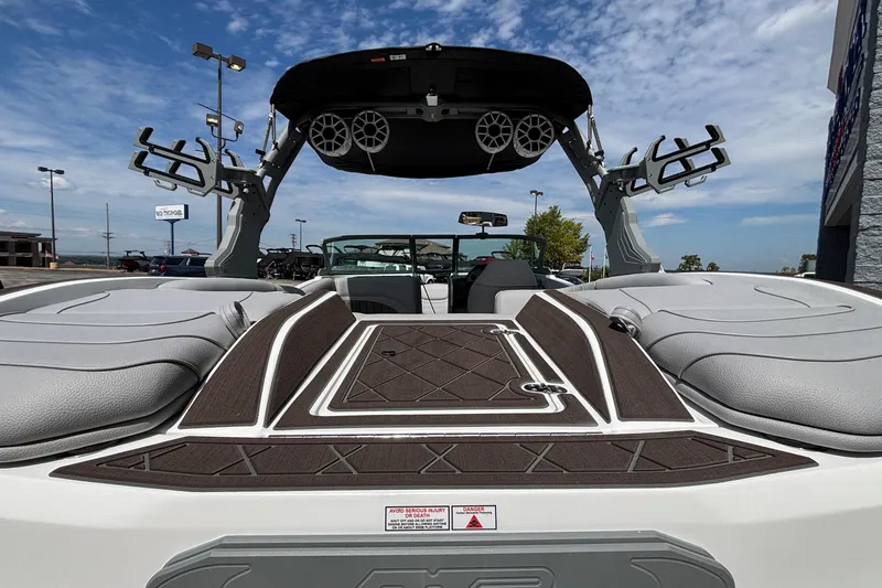 Slide: The Image of 2026 MB B52 23 Alpha boat interior with speakers and seating under a blue sky. - 19