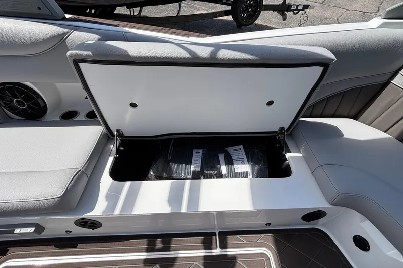 Slide: The Image of 2026 MB B52 23 Alpha boat interior storage compartment with open lid and visible speaker. - 31