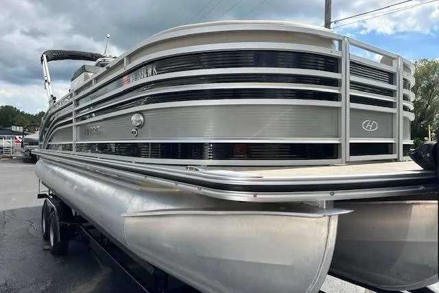 Slide: The Image of 2020 Harris Solstice 250 pontoon boat on trailer, silver exterior, parked outdoors. - 3