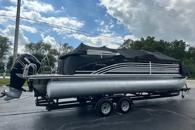 Slide: The Image of 2020 Harris Solstice 250 pontoon boat on trailer, covered, parked outdoors. - 39