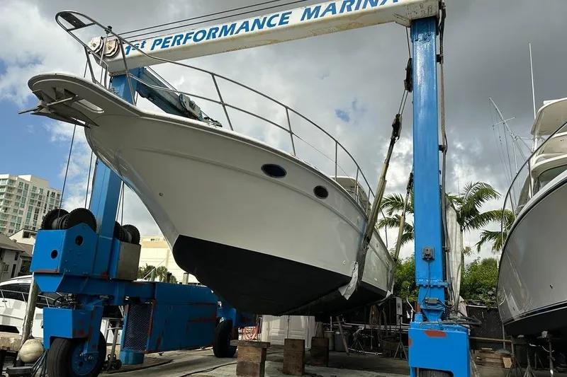 Slide: The Image of 1994 Sea Ray 370 Express Cruiser on lift at marina, cloudy sky background. - 10