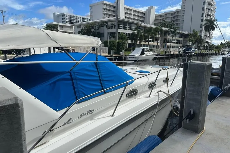 Slide: The Image of 1994 Sea Ray 370 Express Cruiser docked at marina with blue cover. - 11