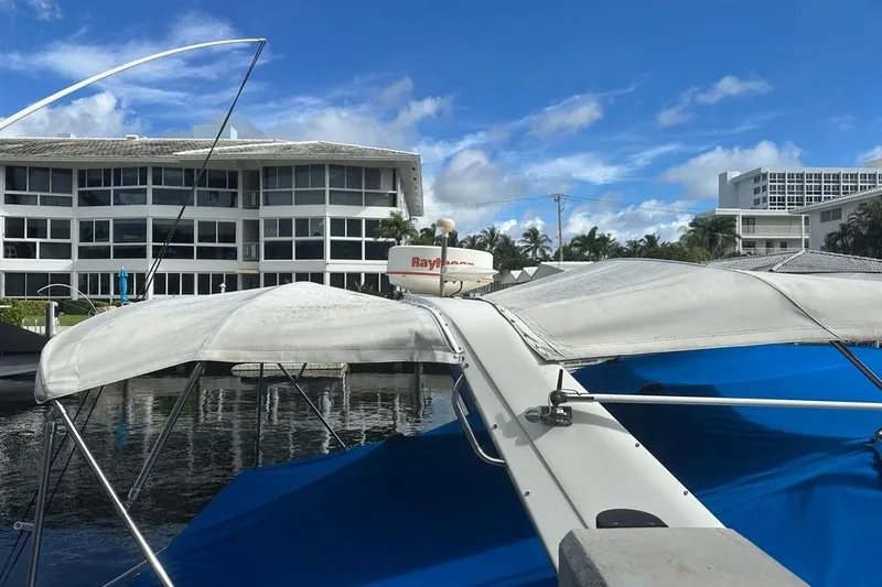 Slide: The Image of 1994 Sea Ray 370 Express Cruiser docked near modern waterfront buildings. - 12