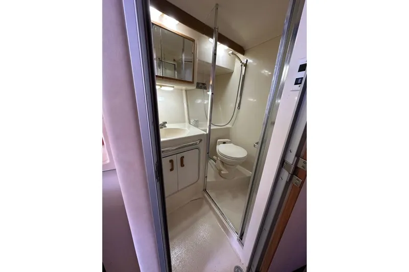Slide: The Image of 1994 Sea Ray 370 Express Cruiser bathroom with shower, sink, and toilet. - 14