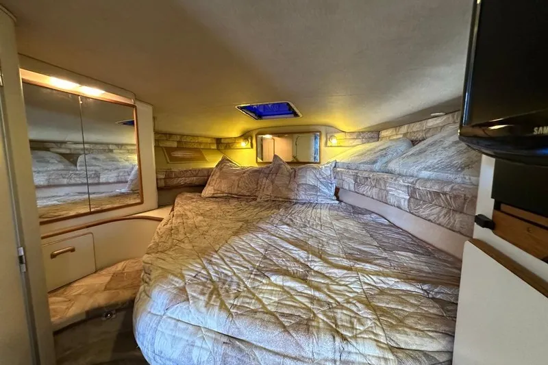 Slide: The Image of 1994 Sea Ray 370 Express Cruiser cabin with cozy bed and ambient lighting. - 16