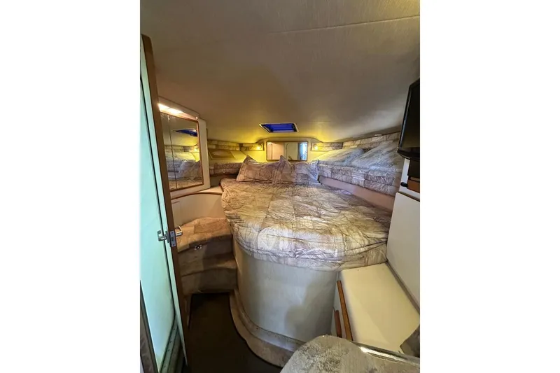 Slide: The Image of 1994 Sea Ray 370 Express Cruiser cabin interior with cozy bed and ambient lighting. - 17
