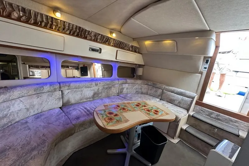 Slide: The Image of 1994 Sea Ray 370 Express Cruiser interior with plush seating and dining table. - 19