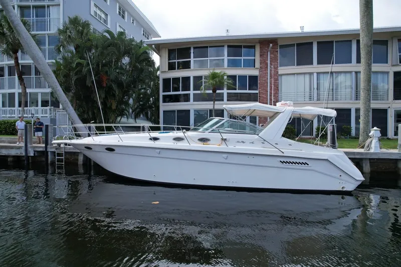 Slide: The Image of 1994 Sea Ray 370 Express Cruiser docked near waterfront apartments. - 2