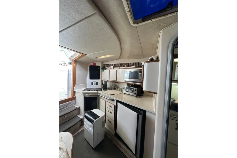 Slide: The Image of Interior of 1994 Sea Ray 370 Express Cruiser with kitchenette and appliances. - 23